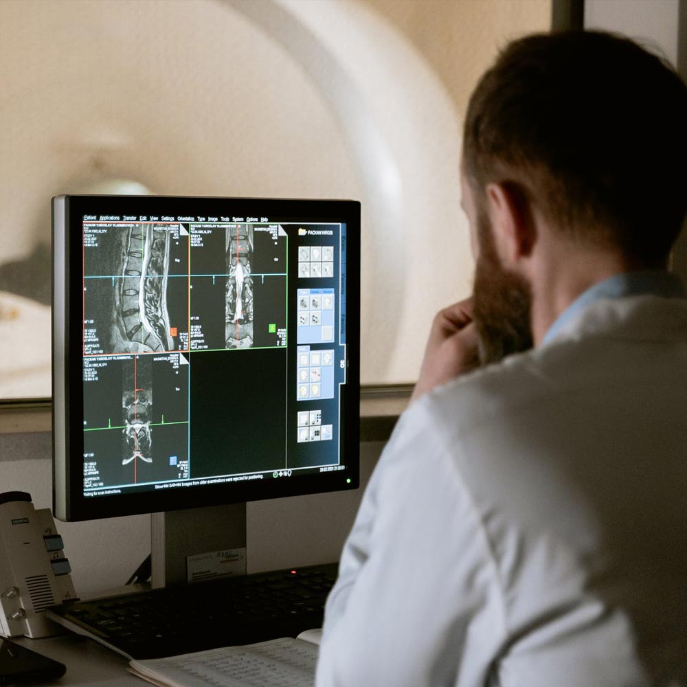 A man looking at the monitor of an MRI machine