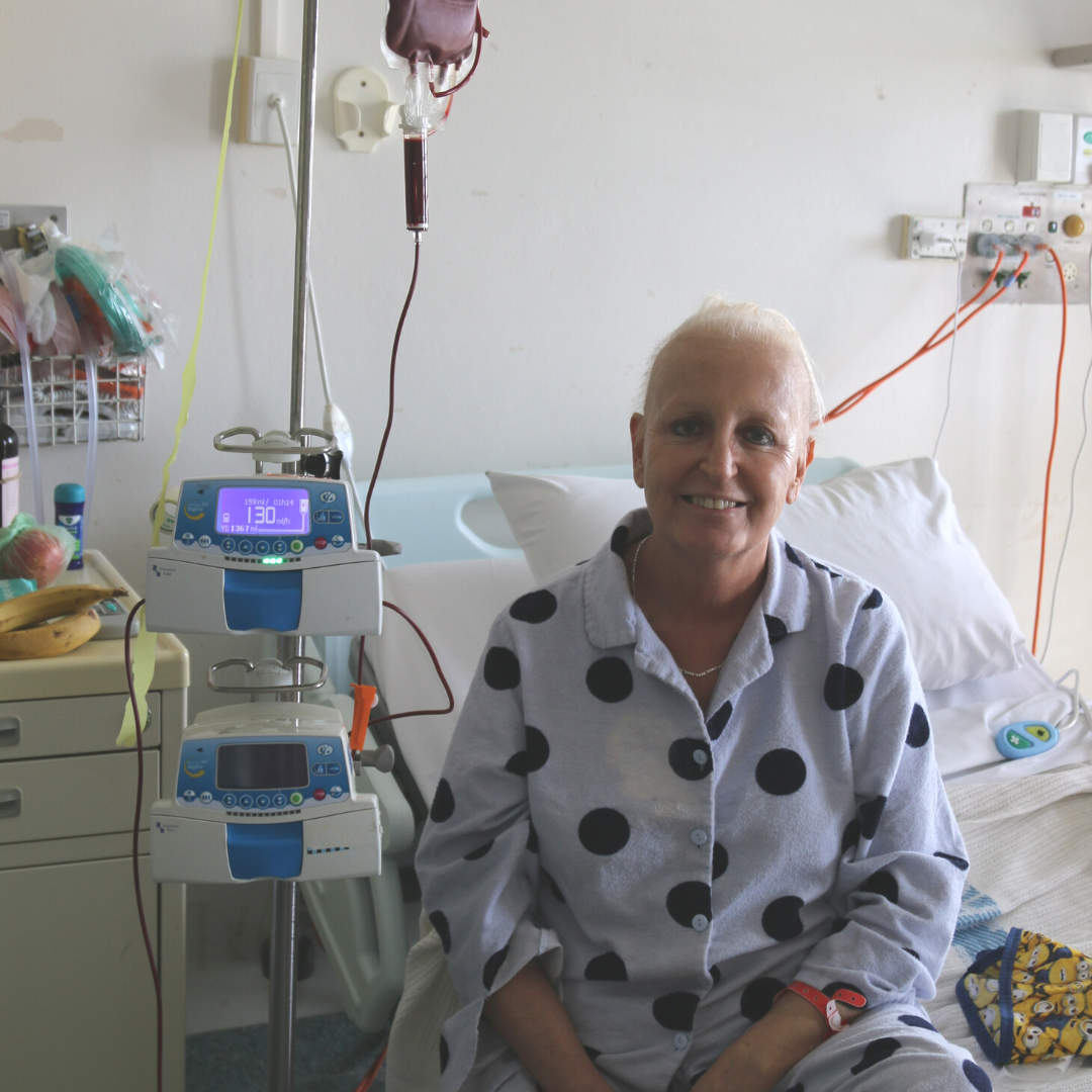 Julie sitting on a hospital bed, smiling