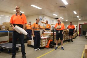 Workers in High vis clothing holding packages