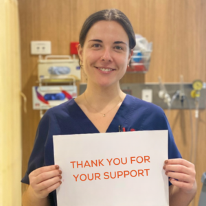 nurse holding a sign saying "thank you for your support"