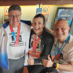 three people who have competed in a marathon all posing together with their thumbs up