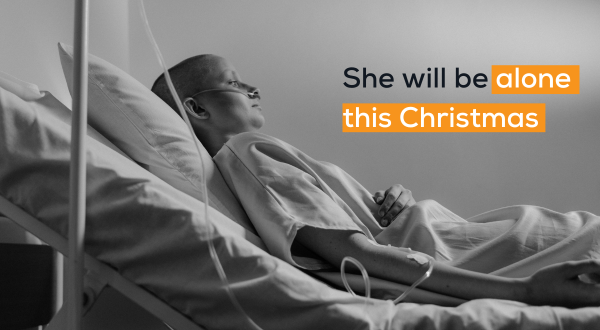 cancer patient sitting alone in her bed. with text reading "she will be along this christmas"
