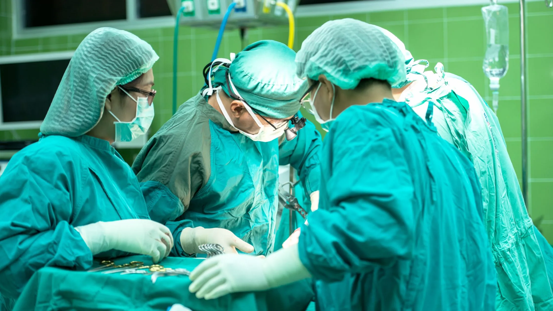 surgeons performing surgery wearing PPE protective clothing