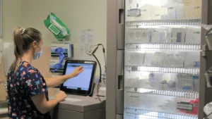 a nurse using an automatic dispensing cabinet to administer medication