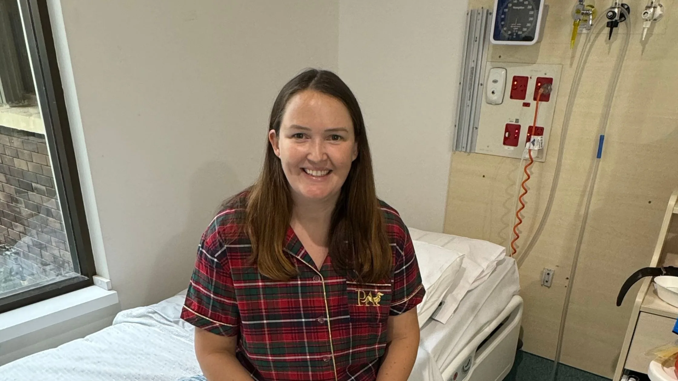 female patient sitting on hospital bed smiling